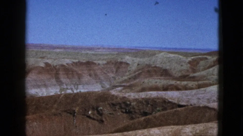1953 California home-movie still showing a wide dry landscape with layered hills and open blue sky.