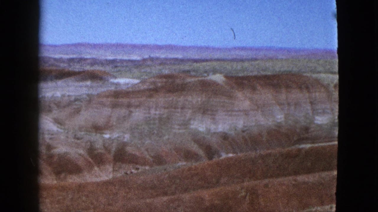 Canyon ridges and eroded gullies stretching toward a distant flat horizon.