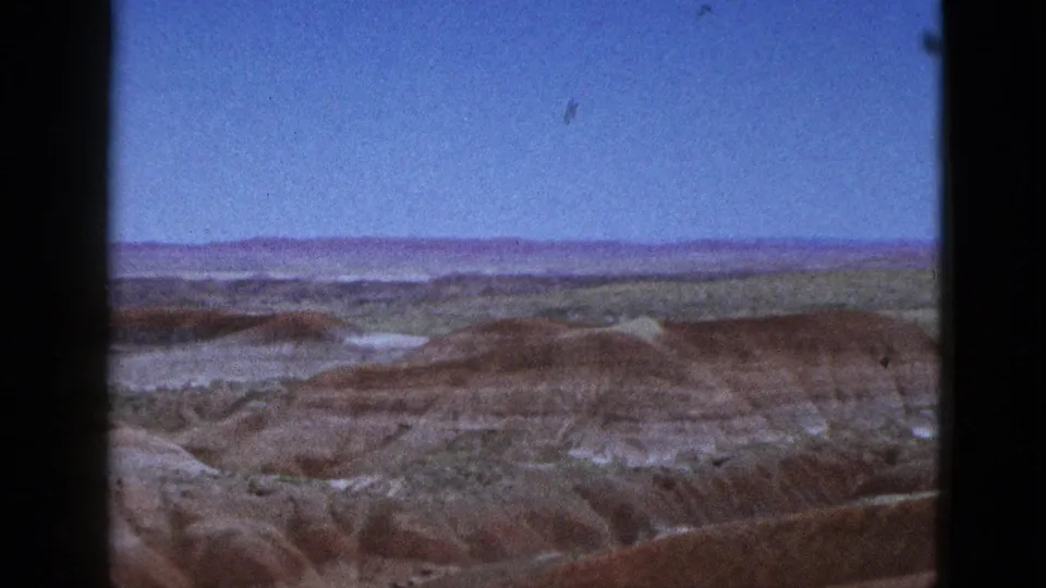 1953 California home-movie frame showing layered desert badlands, soft focus, and an open sky from a visitor overlook.