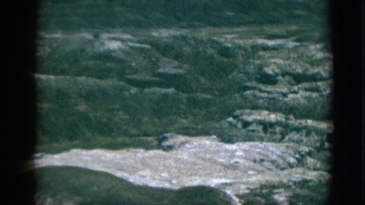 1953 California 8mm frame showing distant rolling hills, pale exposed ground, and soft film-gate edges.