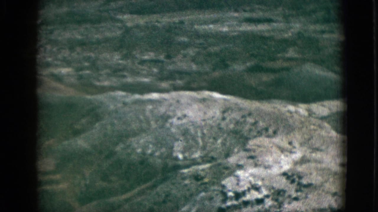 Rugged hillside with green vegetation and light rocky patches under soft daylight.
