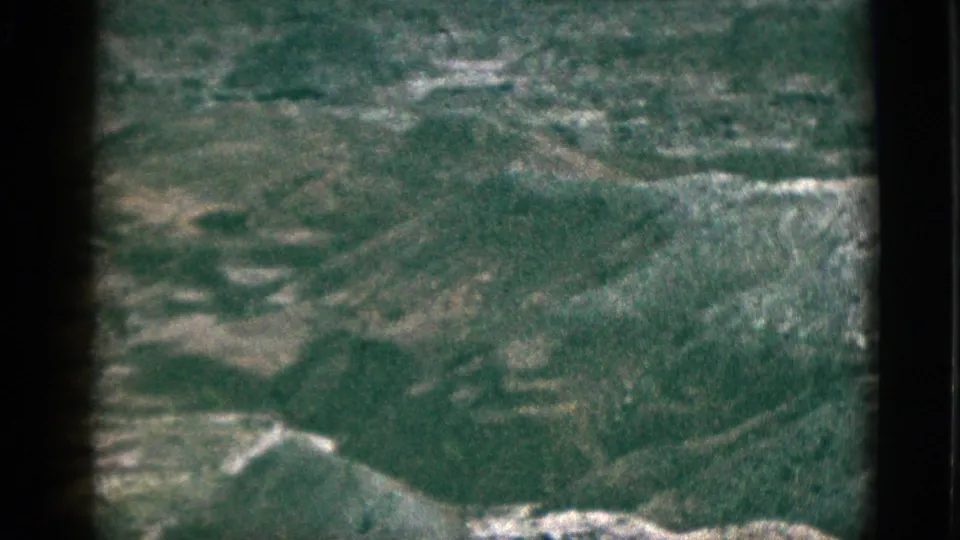 1953 California 8mm frame with broad green hills, faint pale ridgelines, and visible film-frame borders.