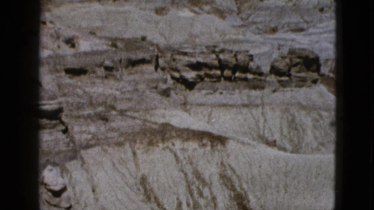 Eroded desert rock formation with horizontal ledges and film gate edges.