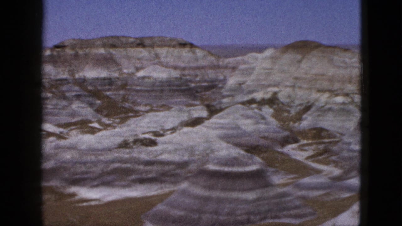 Panoramic desert badlands with stratified hills and dry washes.