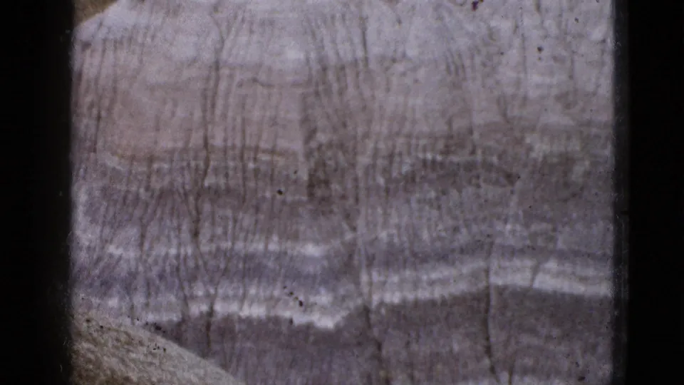 1953 Arizona home-movie frame focused tightly on banded, eroded stone with faint color shifts in the rock.