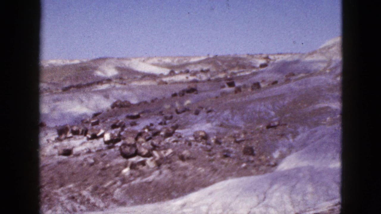 Rocky snow-patched hillside with pale ridge and open sky.
