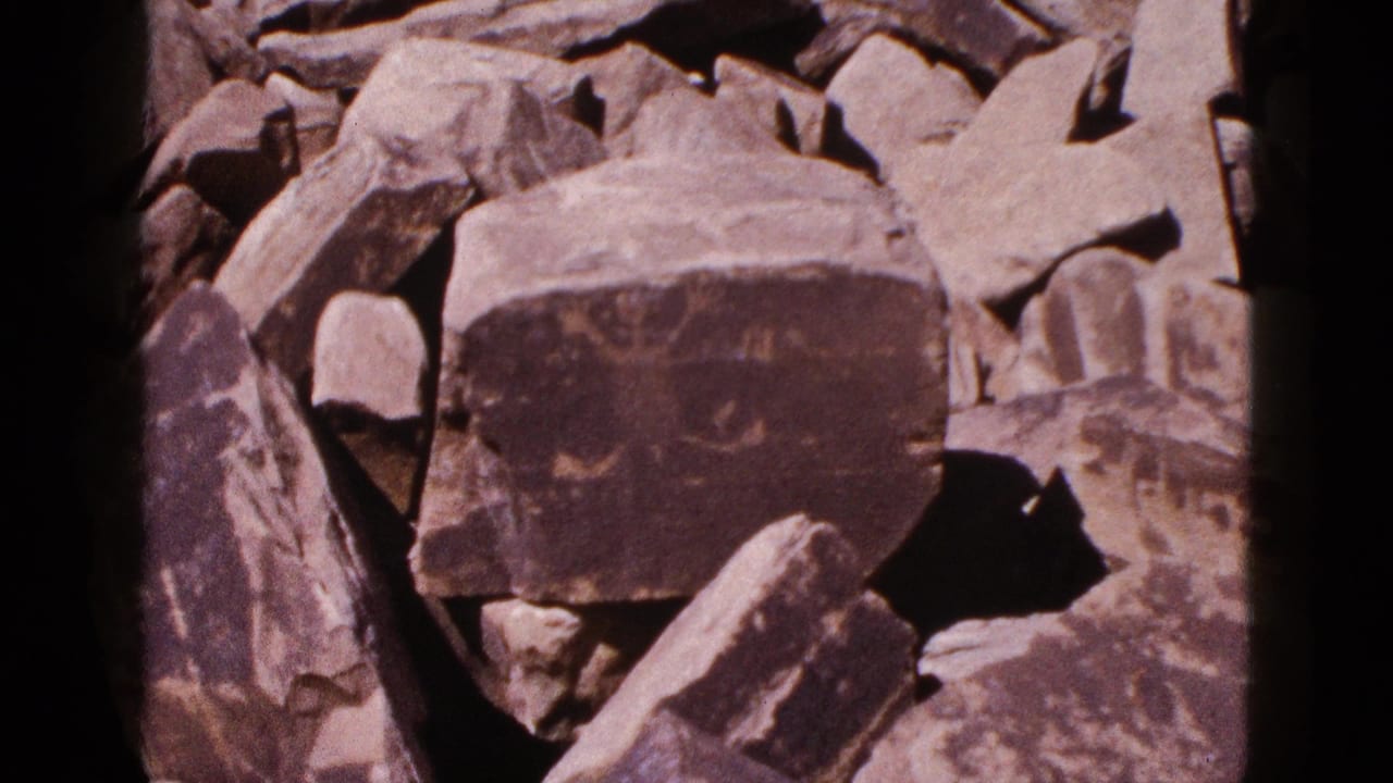 Close view of a carved boulder amid jagged tan and gray rocks.