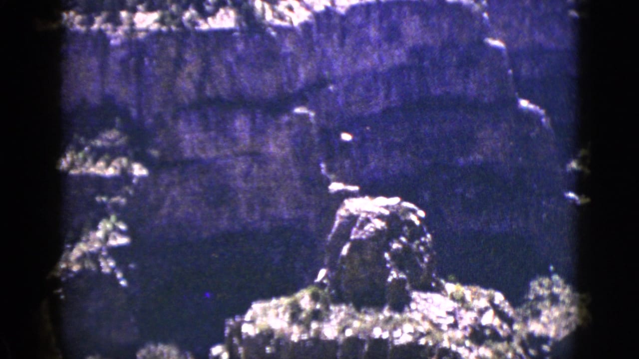 Layered canyon rock formation seen through dark 8mm film borders.