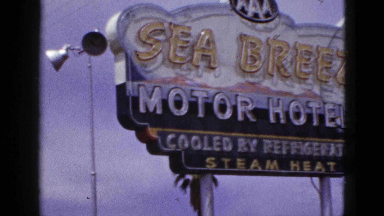 Sea Breeze Motor Hotel sign against a purple-blue sky with dark film borders.