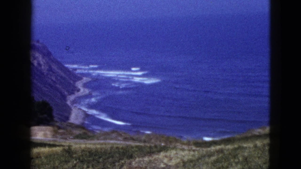 Coastal cliff and surf seen from a high overlook.