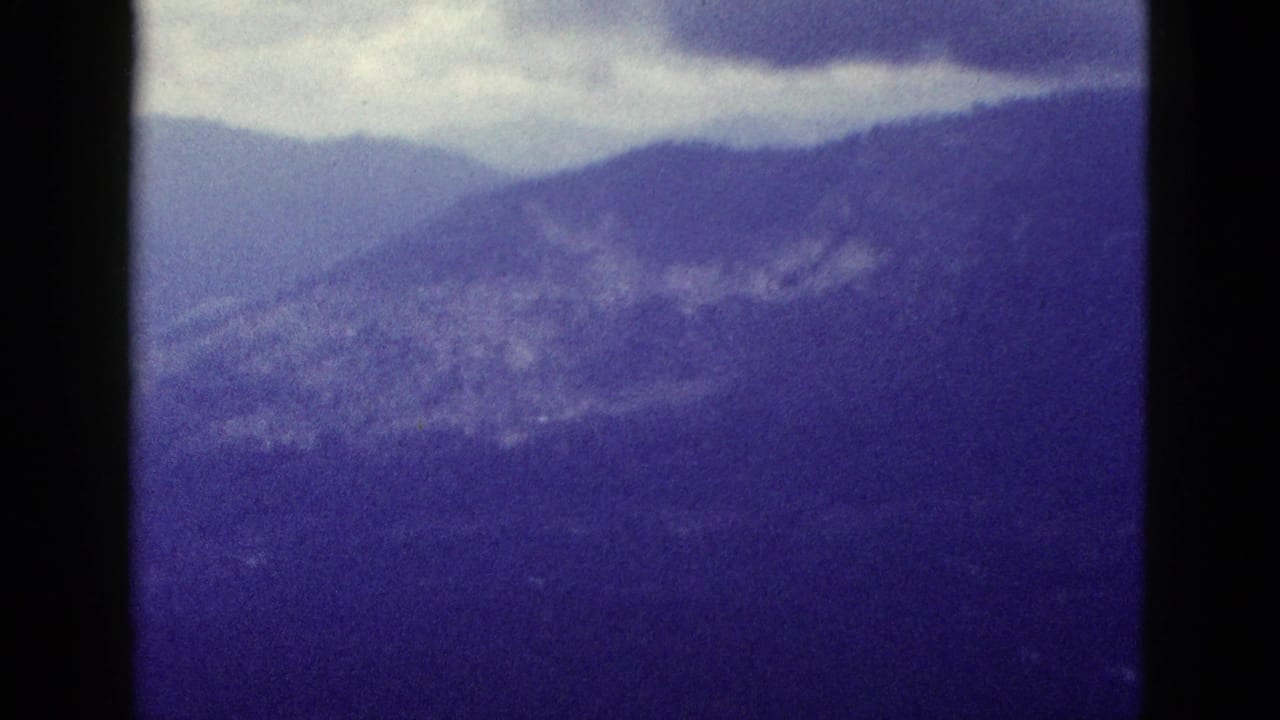 Cloudy sky over hazy mountain ridges with dark 8mm frame borders.