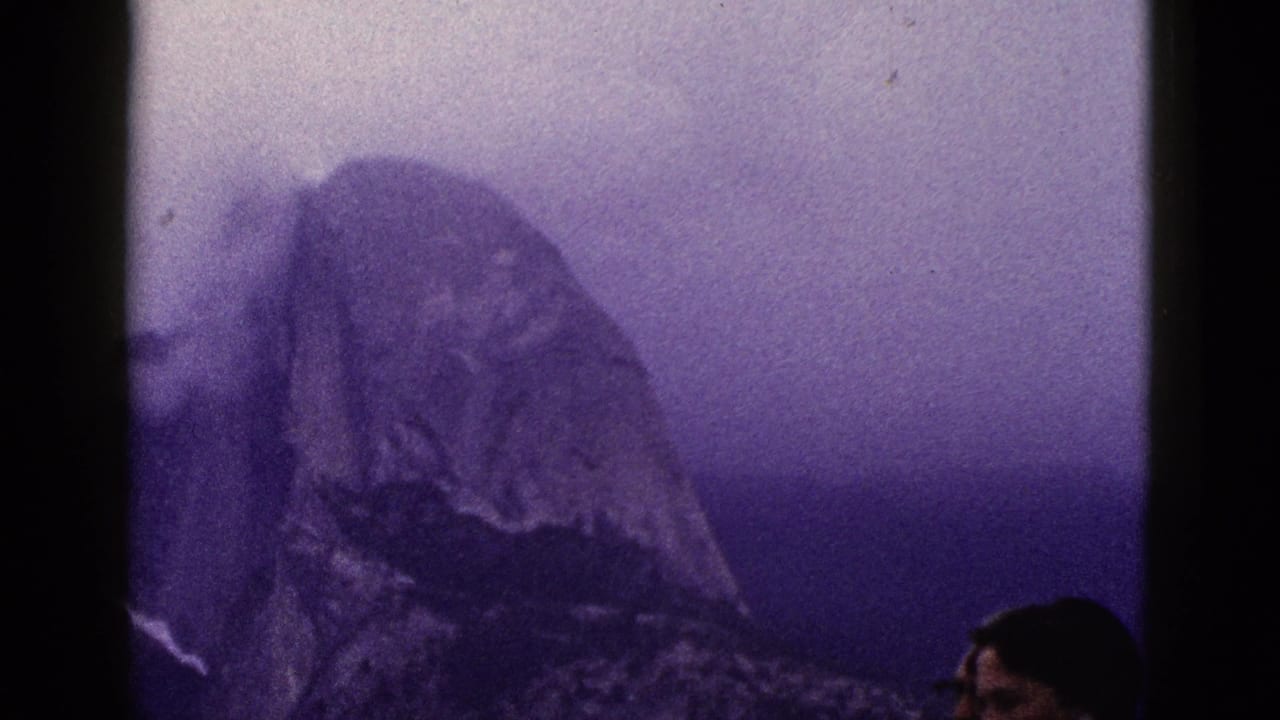 Mountain peak with a partial adult face at the right edge of the frame.