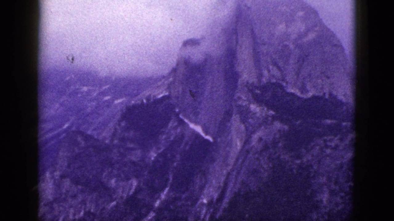 Purple-shifted mountain peak and ridges framed by dark film edges.