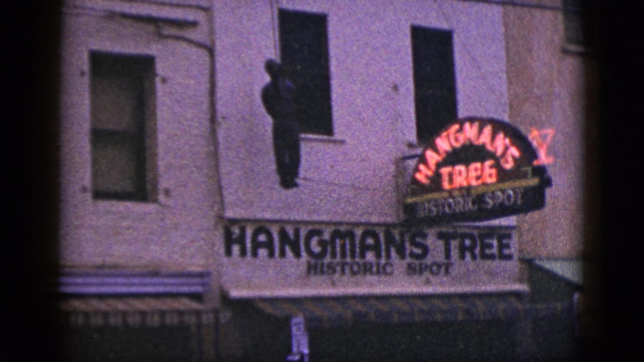 Hangman's Tree Historic Spot sign on a building with a hanging figure silhouette above.
