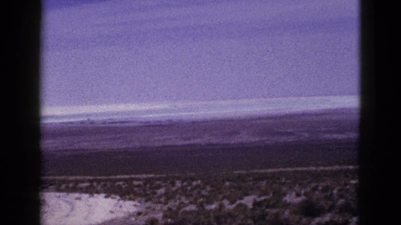 Low desert horizon and cloud bands seen through a dark-bordered film scan frame.