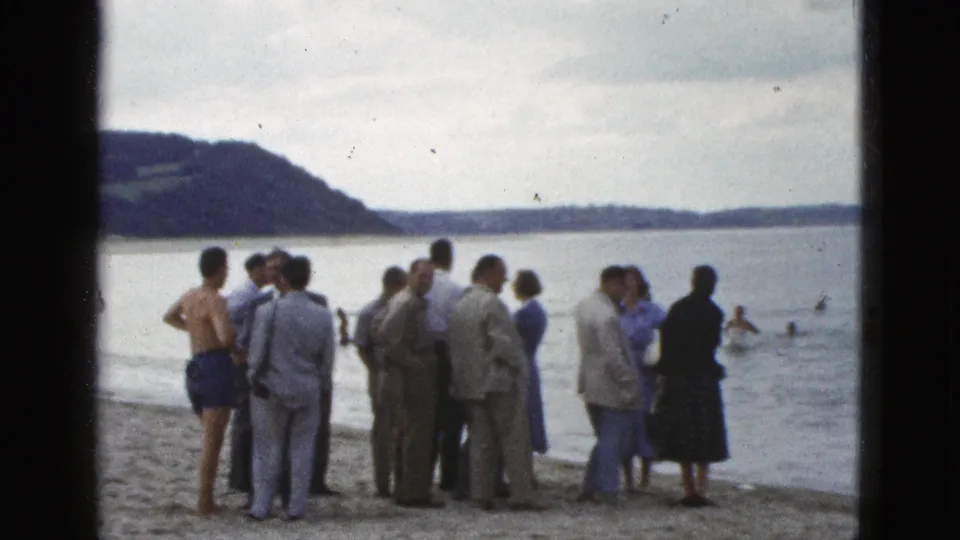 The final 1953 California frame shows spectators in suits, dresses, and swimwear near calm bay water as swimmers approach the shore.