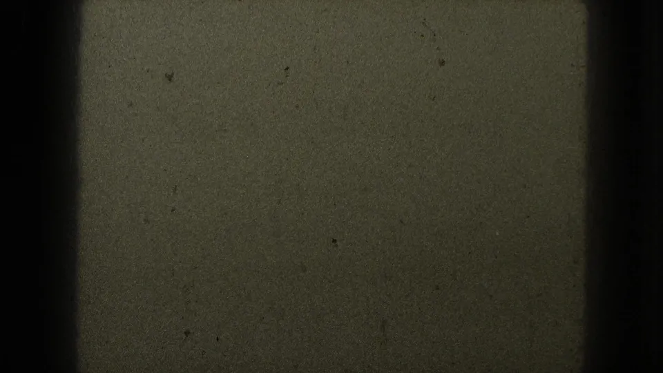 1953 8mm frame from Milwaukee metadata showing dark olive film grain, scattered dust, and heavy black edge shadowing.