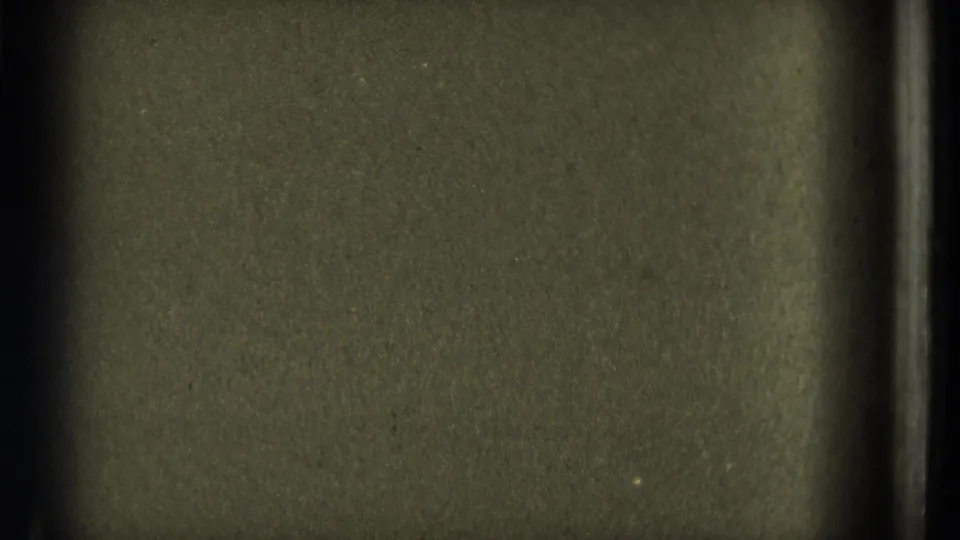 1953 8mm frame showing muted olive grain, uneven exposure, dust, and a dark vertical strip along the right side.