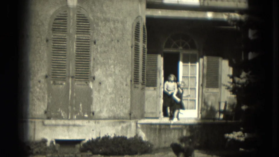 A child or young person appears at the doorway of a Milwaukee residence as the dog remains near the lower edge of the frame.