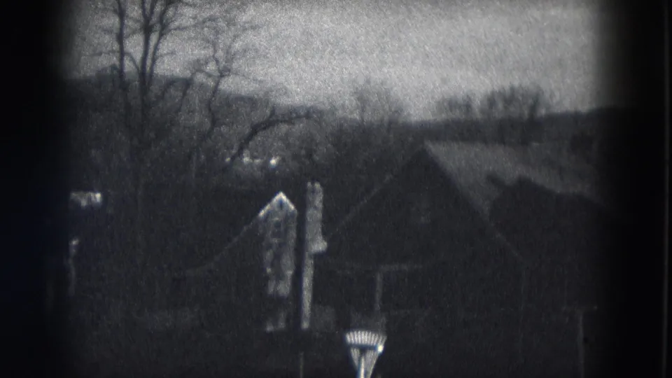 1953 Milwaukee 8mm frame showing leafless trees, shadowed rooftops and nearby houses from an elevated residential view.