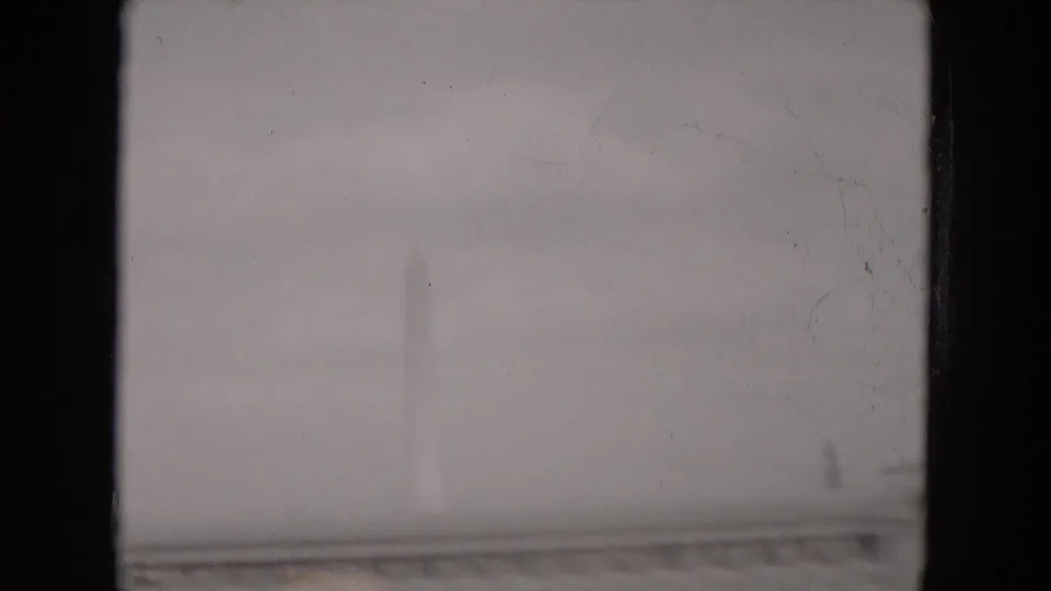 Overcast 1953 Milwaukee frame with a faint white obelisk-like shape partly obscured by haze and exposure softness.