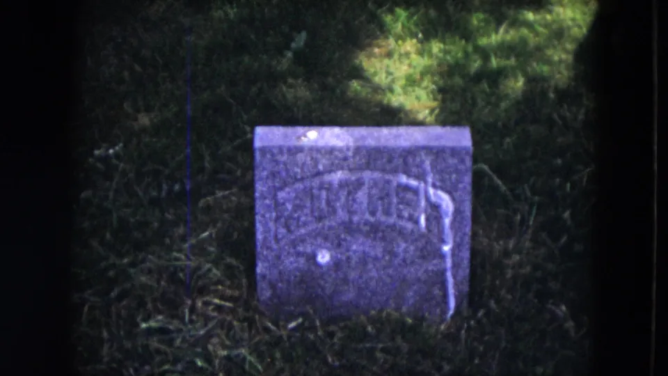1953 Milwaukee 8mm close view of a small weathered gravestone, with WILLIAM lettering visible in a grassy cemetery.