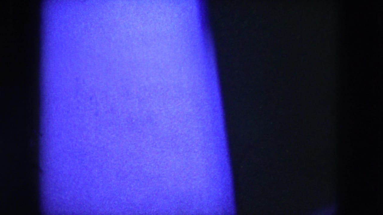 Bright blue-purple ceiling light or exposure flare above a dark lower frame area.