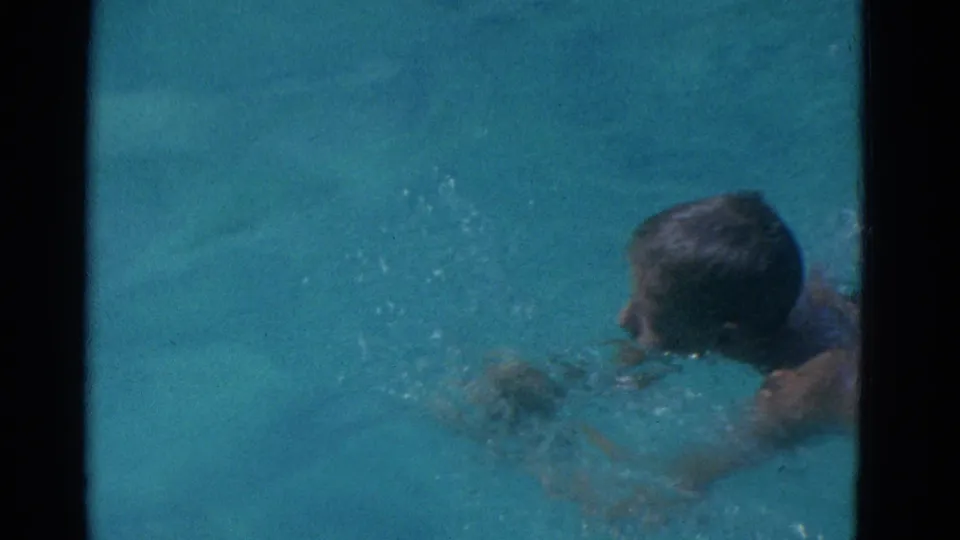 1953 Yonkers 8mm frame showing the swimmer from behind, partly submerged while moving through the pool.