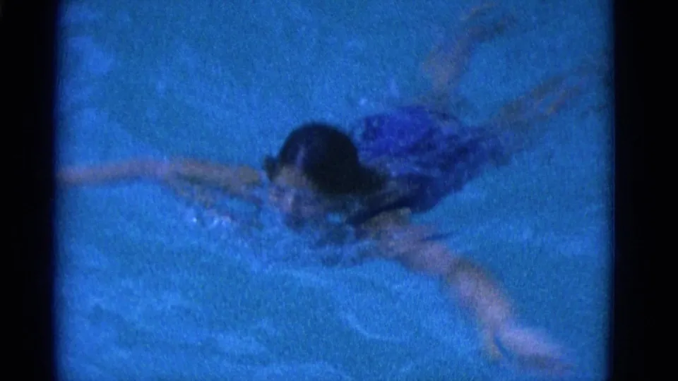 1953 Yonkers 8mm frame showing a swimmer gliding through the pool with one arm extended and water rippling around her.