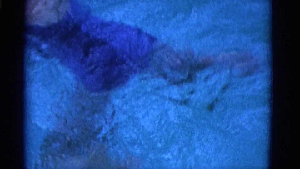 Blue-cast 8mm frame showing blurred underwater movement and ripples in the Yonkers swimming footage.