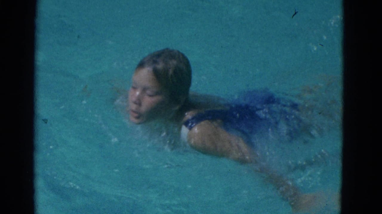 A child swims through turquoise water in a dark blue swimsuit, from 1953 Yonkers home-movie footage per clip metadata.
