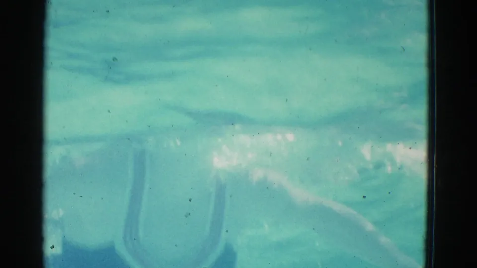 1953 Yonkers pool frame showing blue-green water, soft ripples, dust specks, and visible 8mm gate borders.