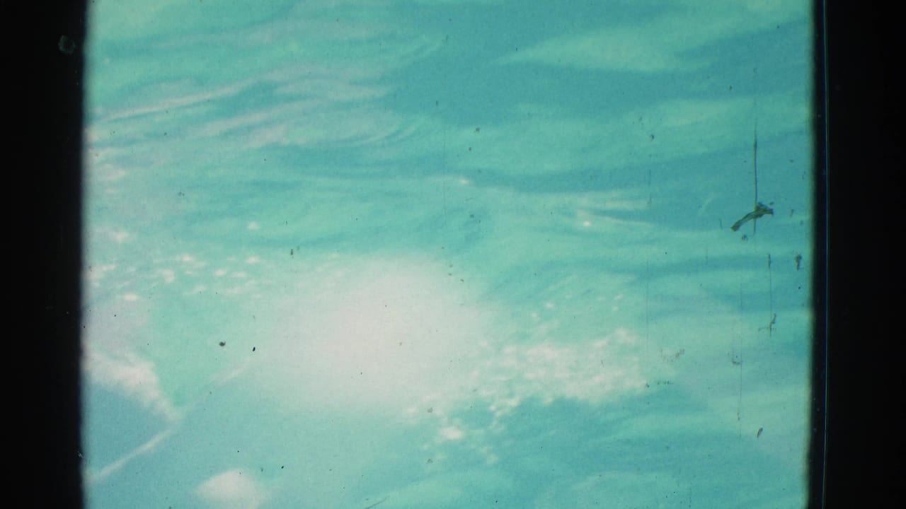 1953 Yonkers home-movie frame showing close turquoise water, surface ripples, reflected light, and visible 8mm film edges.