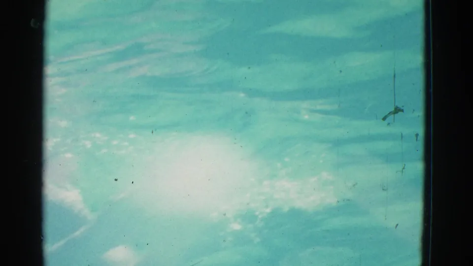 1953 Yonkers home-movie frame showing close turquoise water, surface ripples, reflected light, and visible 8mm film edges.