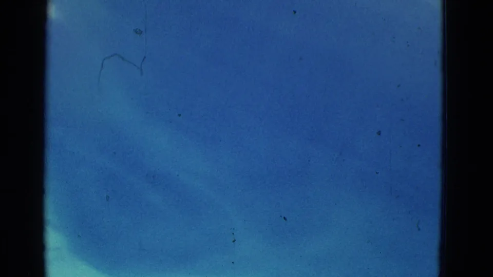 1953 8mm Yonkers underwater pool frame with blue water, faint submerged forms, light falloff, film dust, scratches, and gate borders.