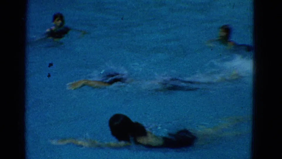 Yonkers 1953 pool scene with multiple swimmers visible above and below the water in a grainy home-movie frame.