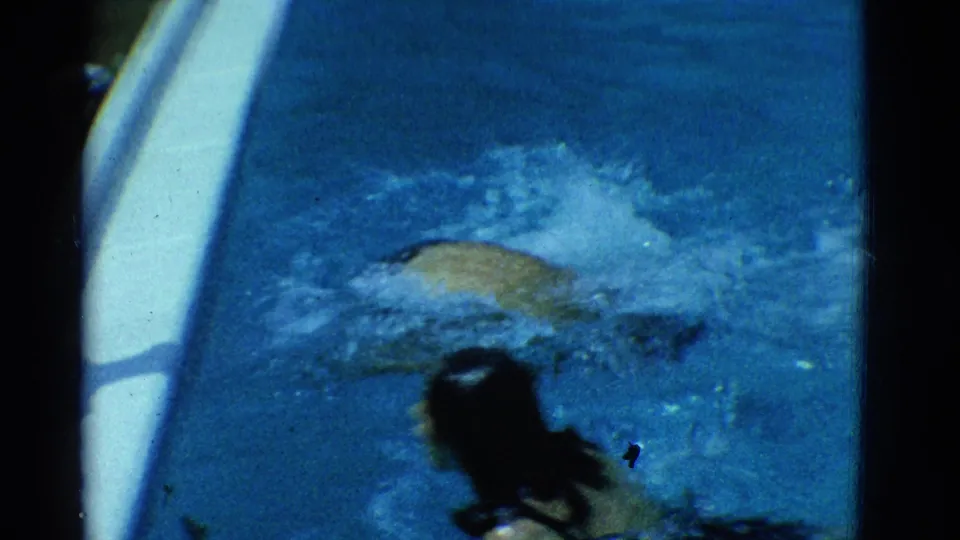 1953 Yonkers pool footage with a swimmer creating a splash near a white ladder and another swimmer in the foreground.