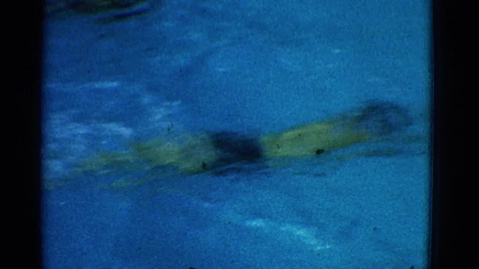 Motion-blurred 8mm view of a swimmer moving through blue water during laps in Yonkers, New York.