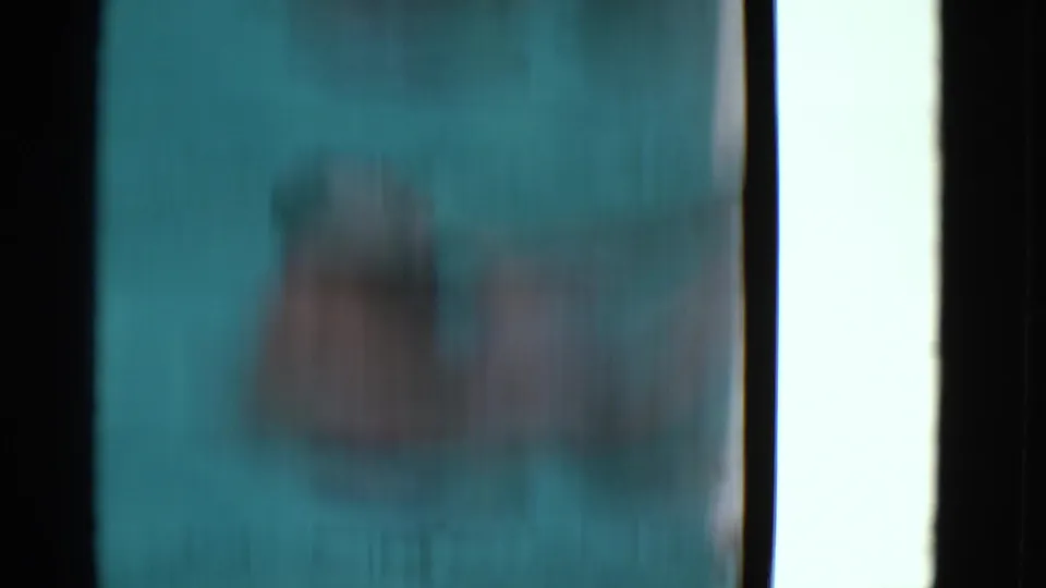 Soft, blurred 8mm frame from the Yonkers pool scene, with turquoise water, dark borders, and indistinct submerged forms.