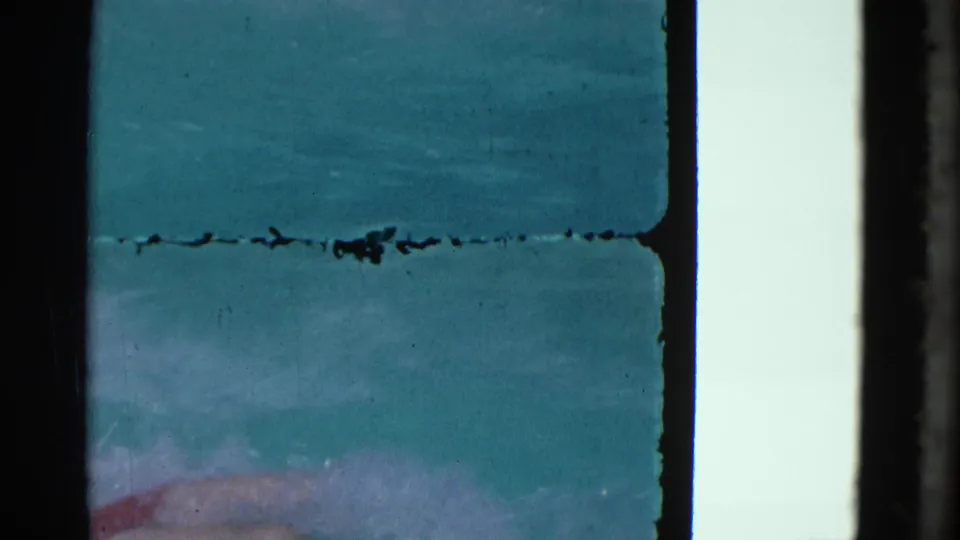 1953 Yonkers pool frame with turquoise water, a partial submerged figure near the lower edge, and prominent 8mm scratch marks.