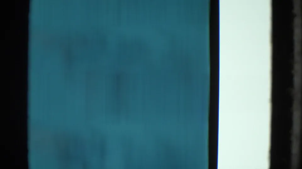 End frame from the 1953 Yonkers clip showing abstract blue-green film texture with dark vertical borders and no clear subject.