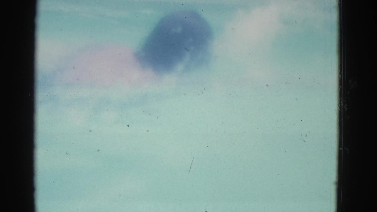 1953 8mm Yonkers pool footage showing pale water and an indistinct swimmer shape near the top of the frame.