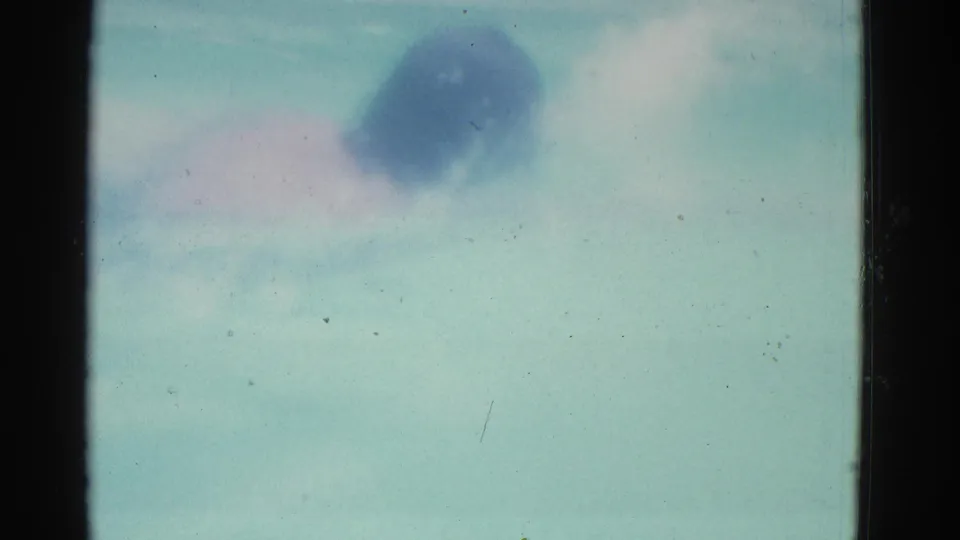 1953 8mm Yonkers pool footage showing pale water and an indistinct swimmer shape near the top of the frame.