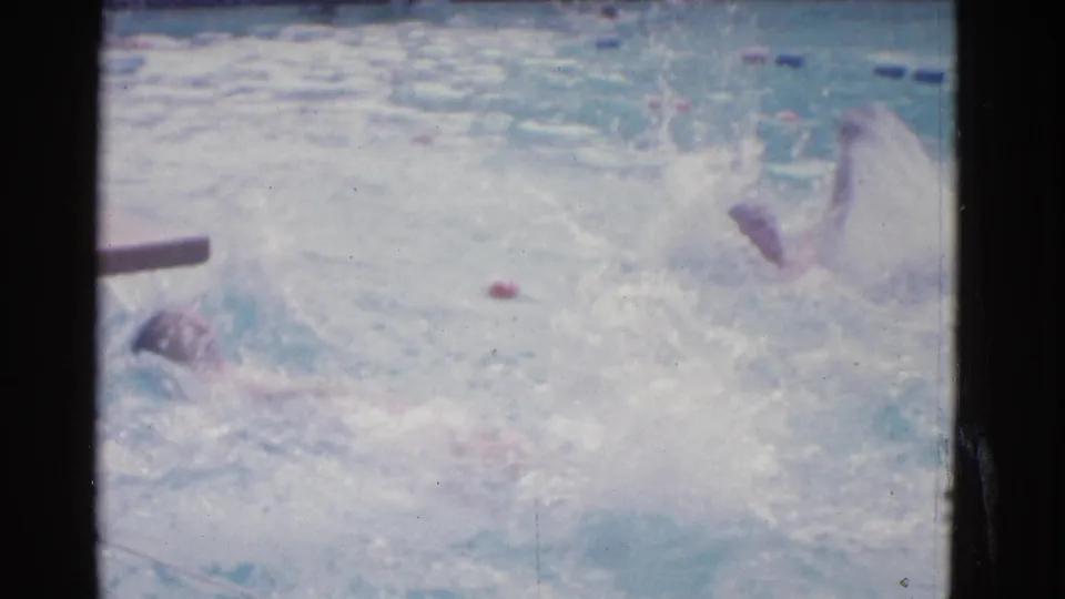 1953 Yonkers outdoor pool footage showing women swimming backstroke near lane dividers, partly obscured by splash and soft focus.