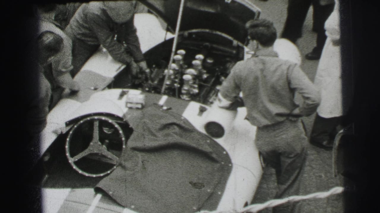 Pit crew work around the open hood of a Mercedes-Benz race car.