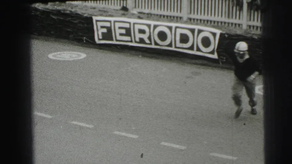 At Le Mans in 1954, a helmeted driver appears to run across the track with a Ferodo sign visible beyond the road surface.