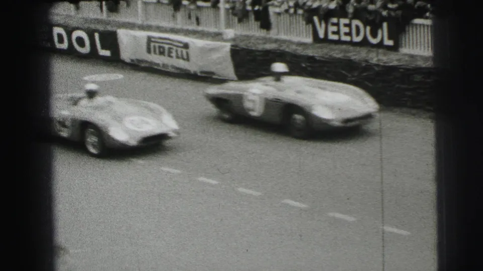 1954 Le Mans footage shows two race cars speeding past trackside barriers with spectators and Pirelli and Veedol signs visible.