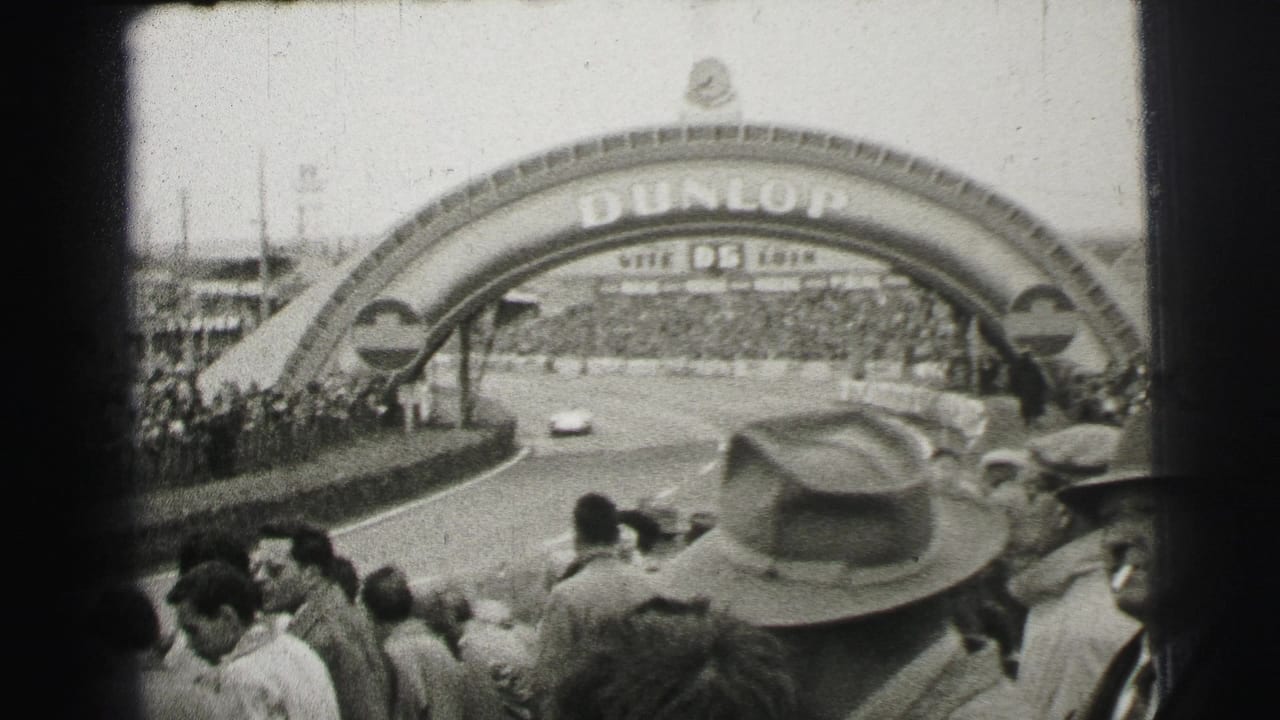 1954 Le Mans frame with a racing car under the Dunlop arch and crowded spectator areas lining the track.
