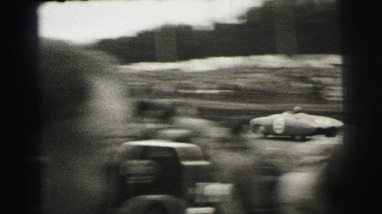 Motion-blurred racing action at Le Mans, with cars and trackside spectators captured through handheld 8mm framing.