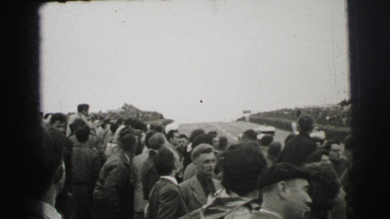 Crowded Le Mans trackside scene from 1954, with spectators in coats and caps watching the course from close range.